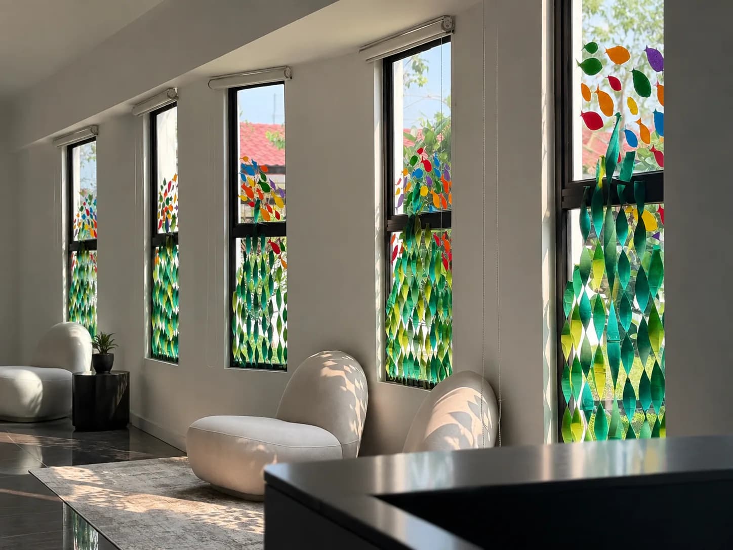 Classroom at The Preschool by The Intelligent Group, with tall windows of coloured glass panels and soft rounded seating